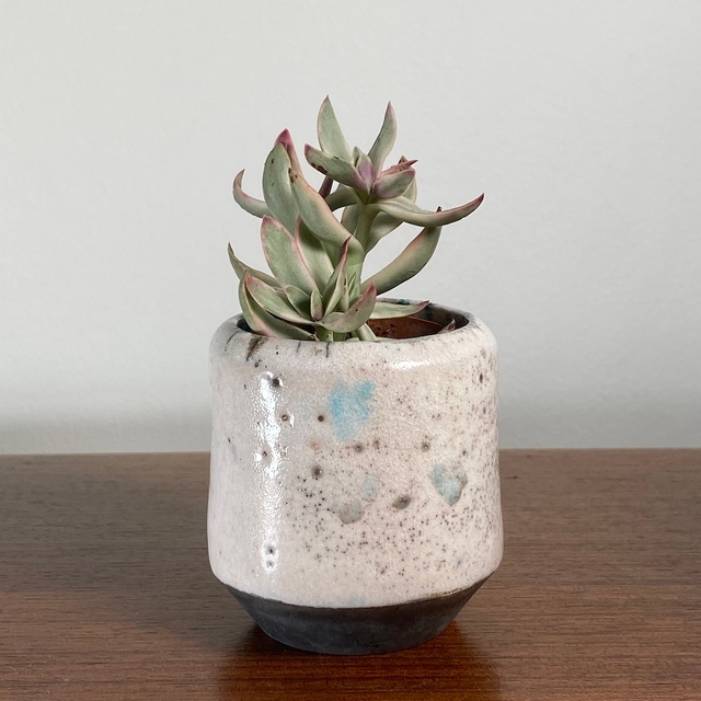 Small white-glazed raku cylinder with copper oxide