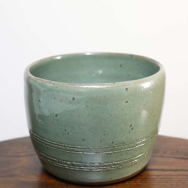 Incised vulcan clay pot with green glaze