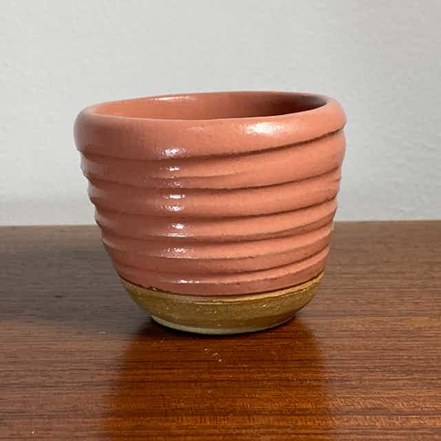 Pink teacup with incised horizontal lines